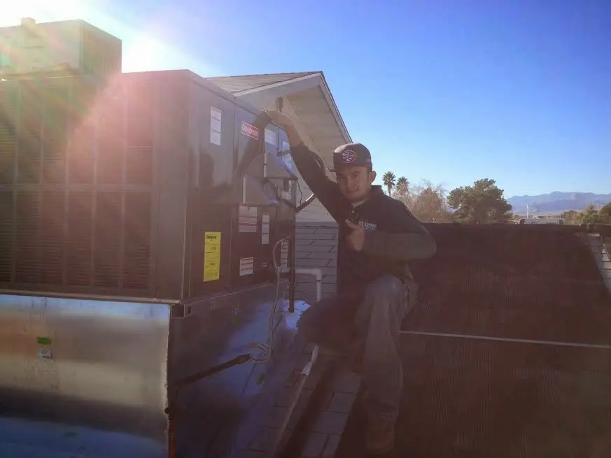 HVAC technician performing AC Tune-Up on a rooftop unit in Hayden